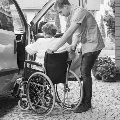 caretaker helping elder lady in wheelchair