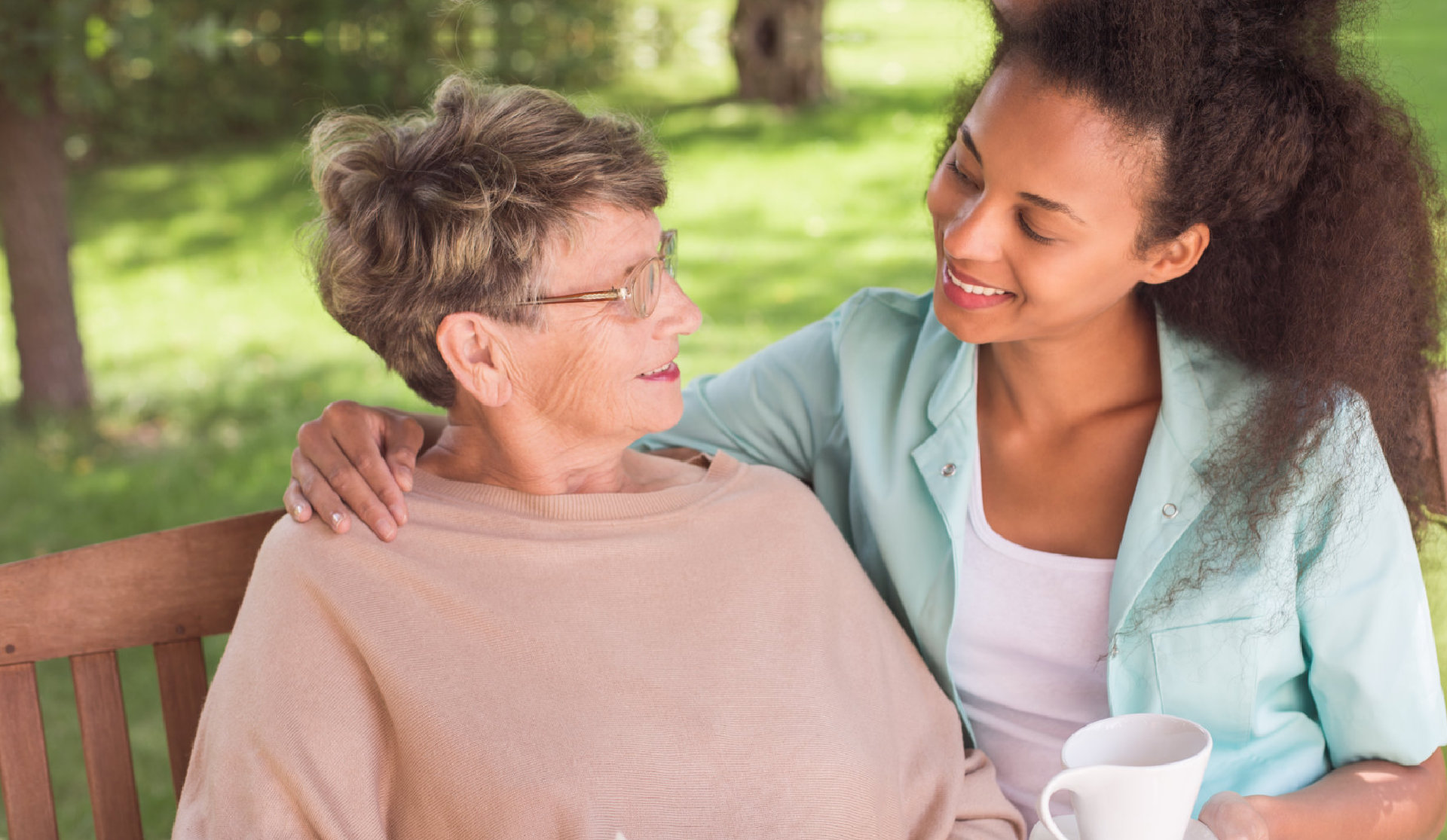 caretaker sits beside elder lady