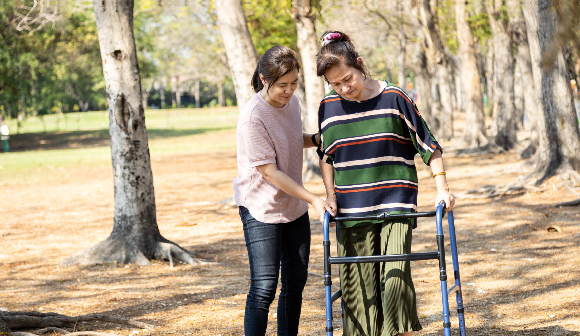 woman helps elder lady in walker